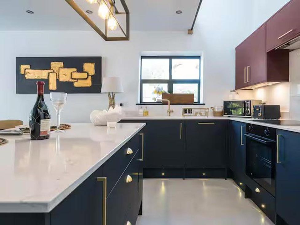 A kitchen with modern appliances and decorative art at The Old Barn in Manchester
