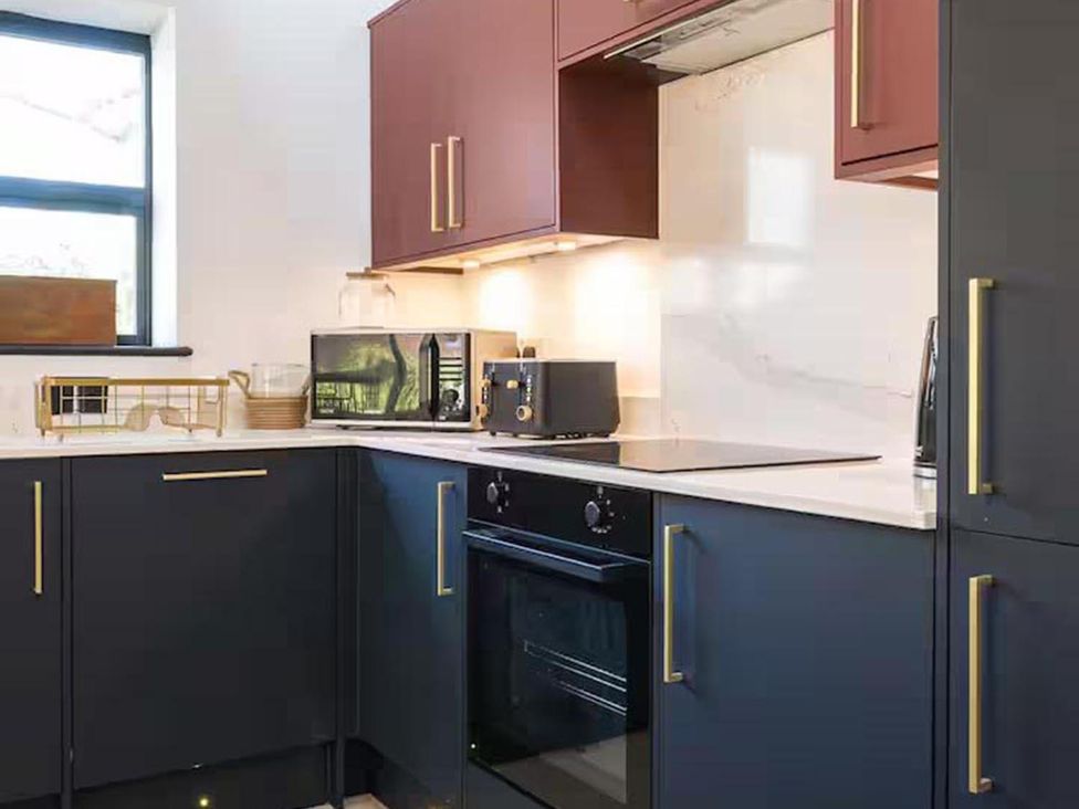 A kitchen with appliances including an oven and microwave at The Old Barn in Manchester