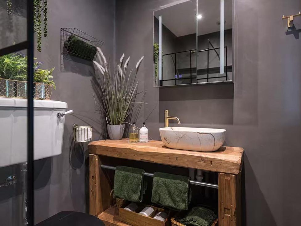 A bathroom with a wooden sink and toilet at The Old Barn in Manchester