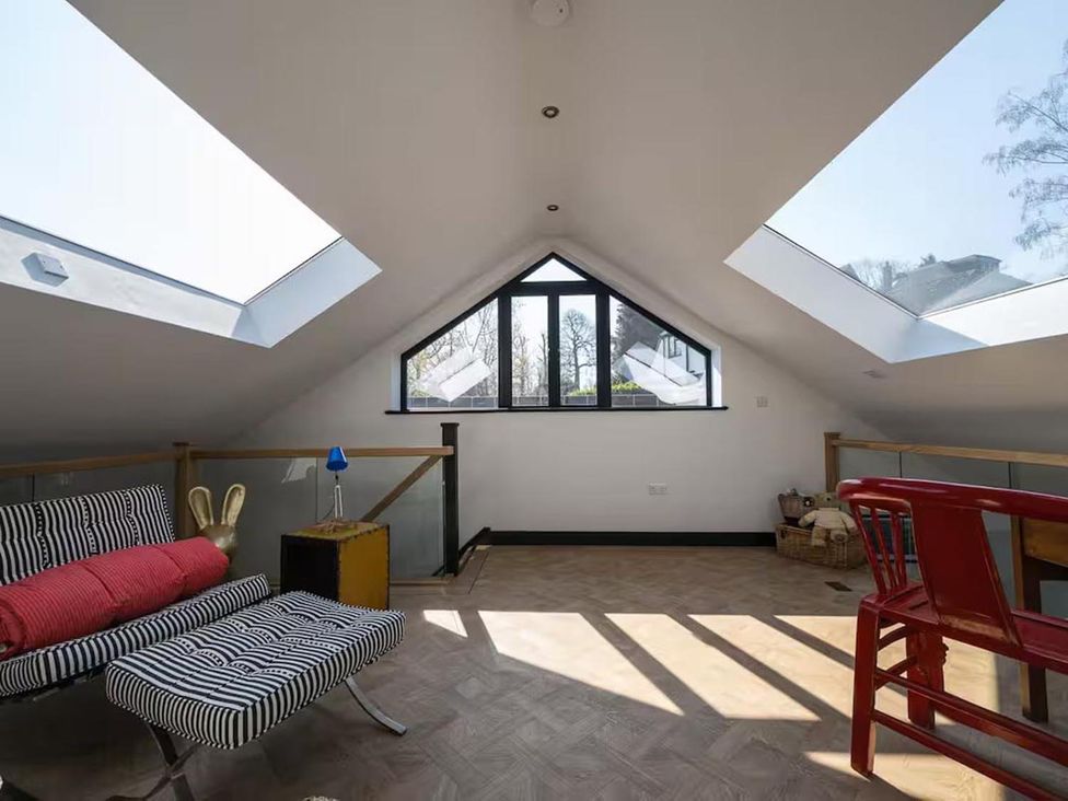 An attic space with a sofa chair and a table at 