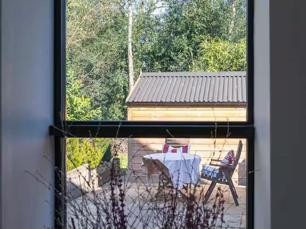 A view of a table and chair set outside near a shed at the property