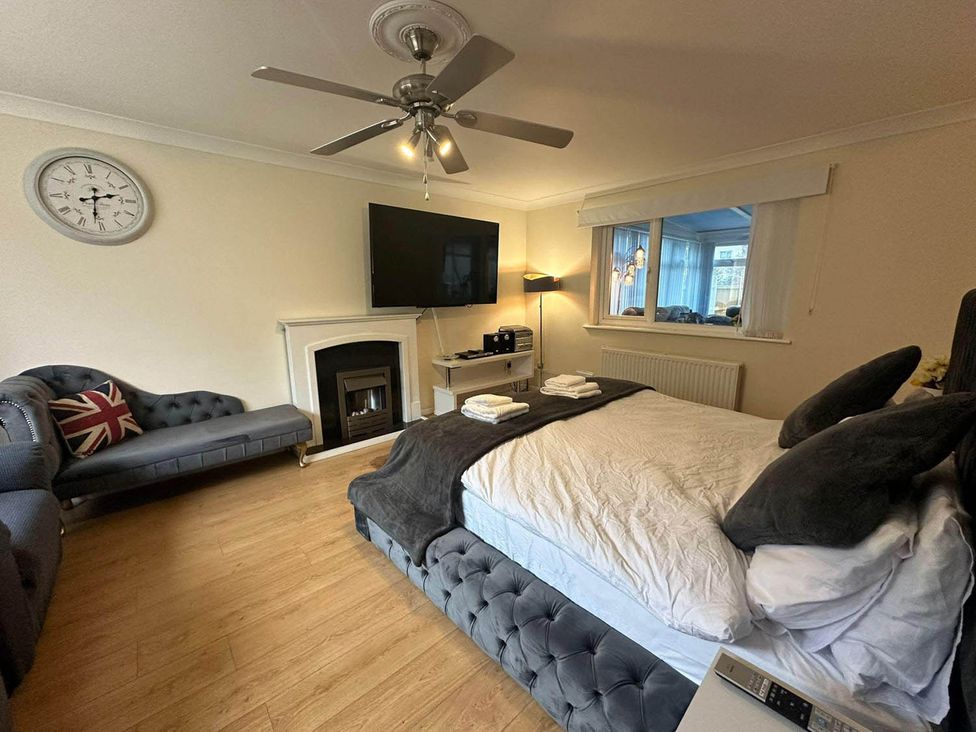 A bedroom with a bed and sofa at 4 Bed House Sleeps 8 Pets Parking Wifi