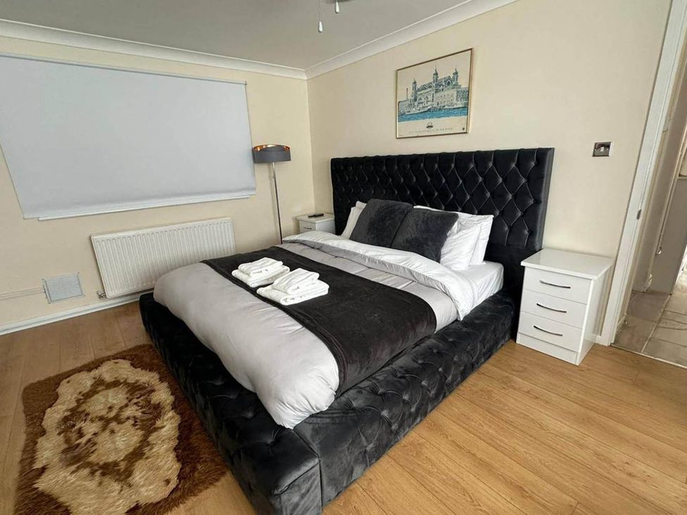 A bedroom with a bed and bedside table at 4 Bed House Sleeps 8 Pets Parking Wifi