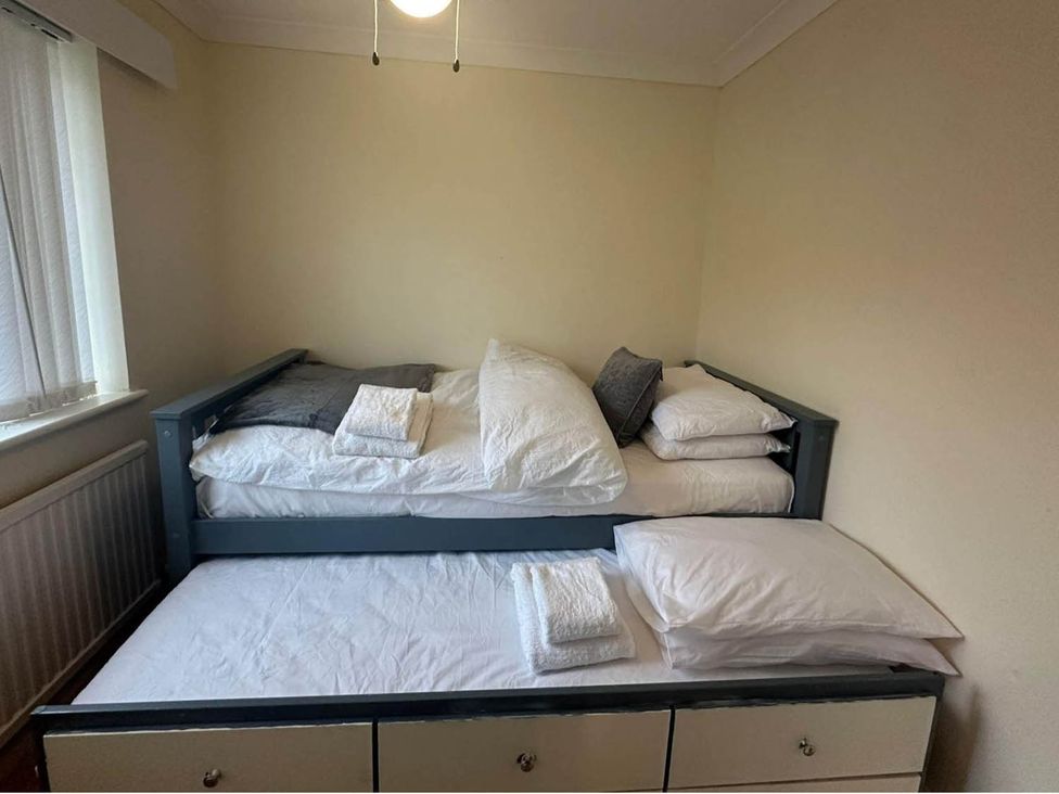 A bedroom with a bed and pillows at 4 Bed House Sleeps 8 Pets Parking Wifi