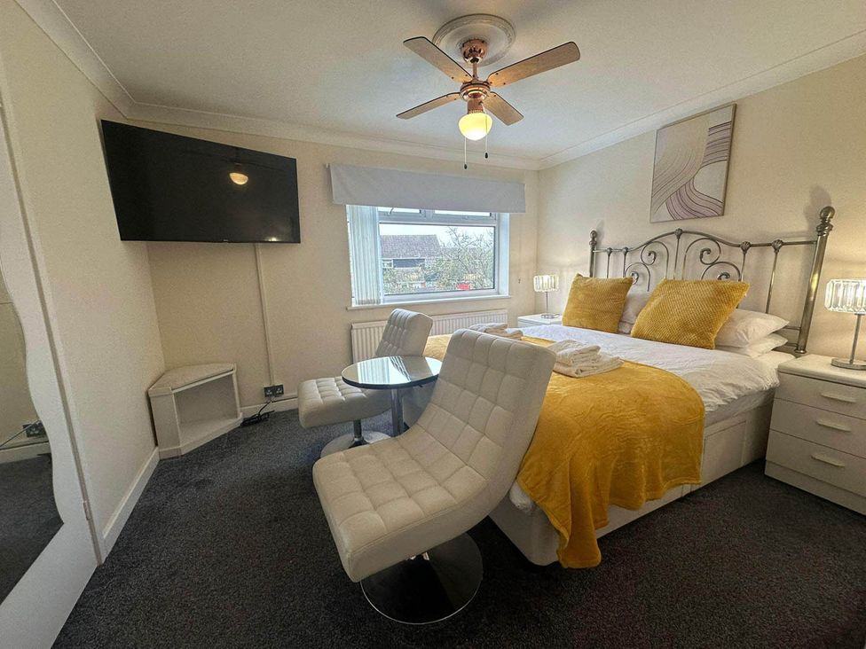 A bedroom with a bed and table in a modern style at 4 Bed House Sleeps 8 Pets Parking Wifi