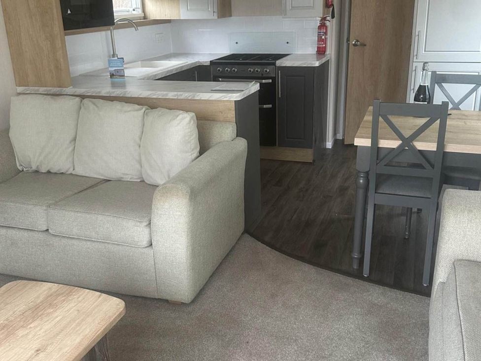 A living room with a sofa and dining area at Charming Caravan in beautiful Seton Sands Cockenzie And Port Seton