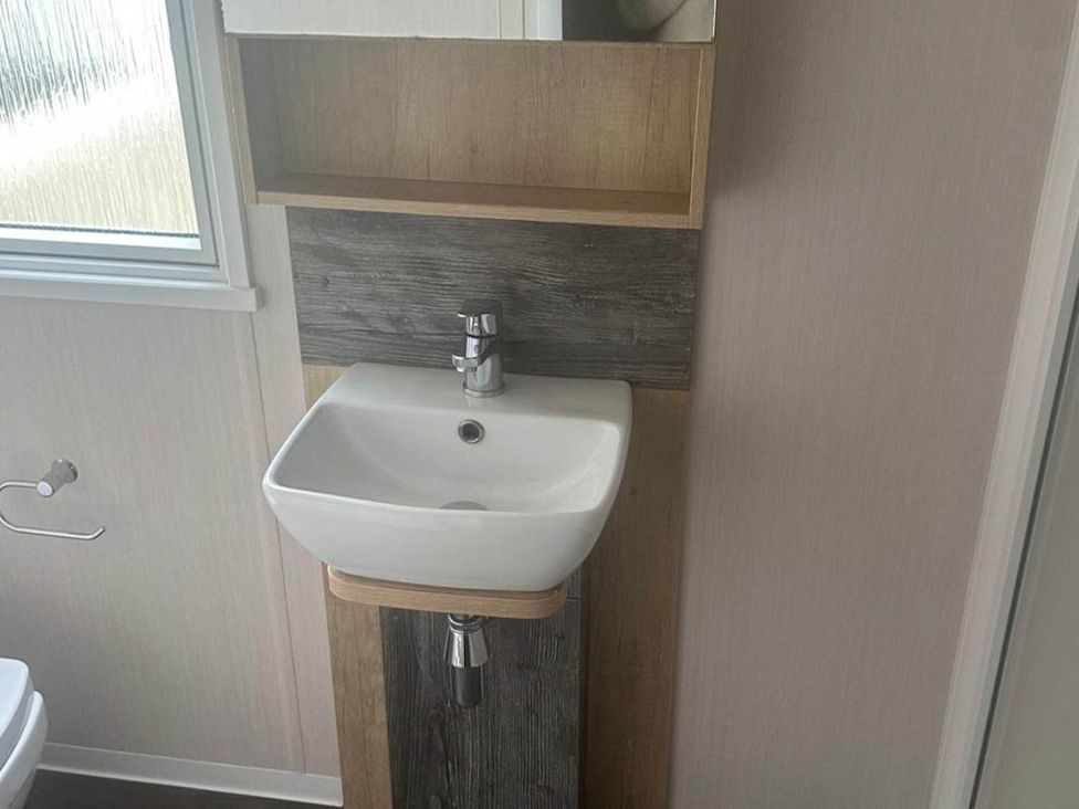 A sink with a faucet and mirror in the bathroom at Charming Caravan in beautiful Seton Sands, Cockenzie And Port Seton