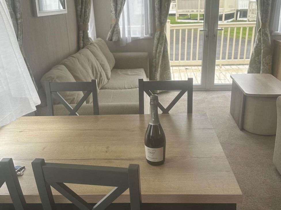 A living room with a sofa and dining table at Charming Caravan in beautiful Seton Sands Cockenzie And Port Seton