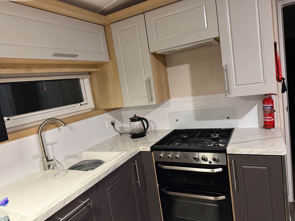 A kitchen with stove, sink, and kettle at Charming Caravan in beautiful Seton Sands Cockenzie And Port Seton