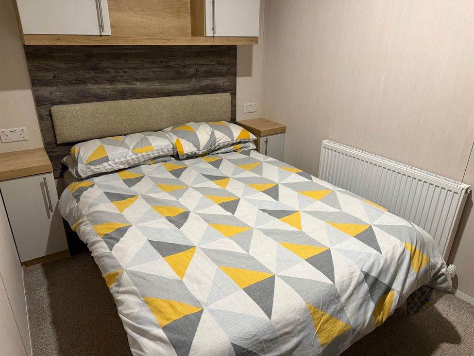 A bedroom with a bed and cupboard at Charming Caravan in beautiful Seton Sands Cockenzie And Port Seton