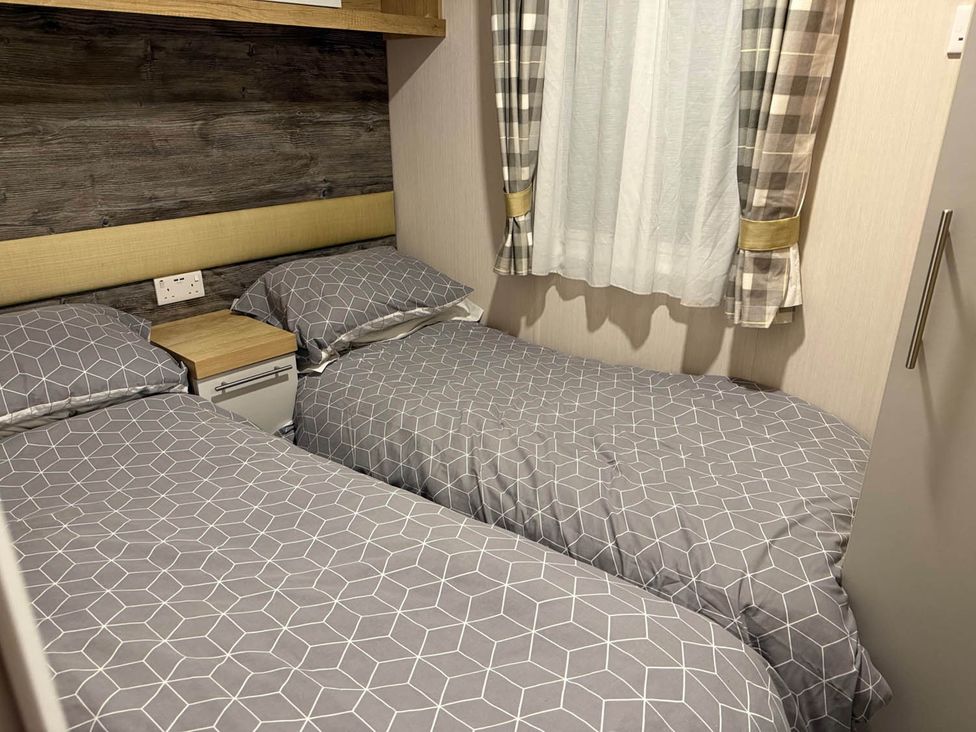 A bedroom with two single beds and a window at Charming Caravan in beautiful Seton Sands Cockenzie And Port Seton