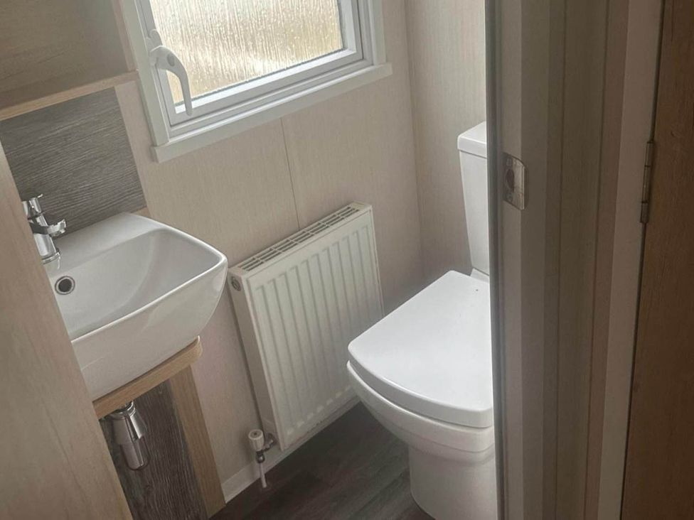 A bathroom with a sink, toilet, and radiator at Charming Caravan in beautiful Seton Sands Cockenzie And Port Seton