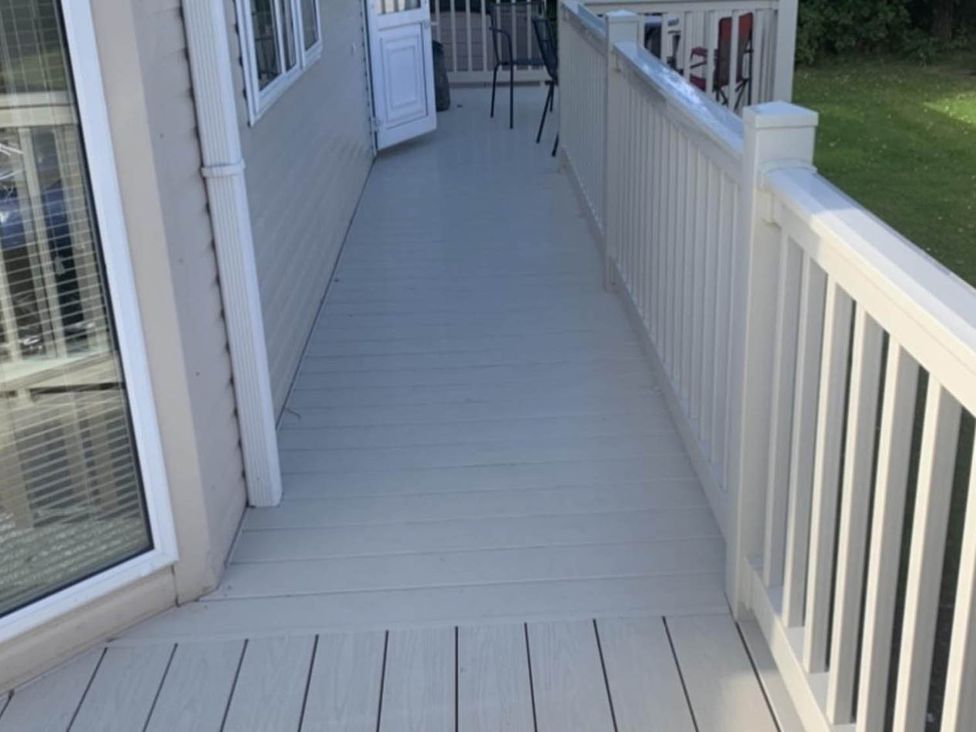 A porch area with decking and a door at Charming Caravan in beautiful Seton Sands, Cockenzie And Port Seton