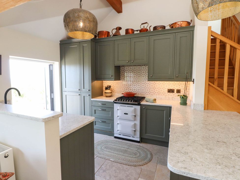 A kitchen with cabinets and a cooker at Hafod in Nefyn