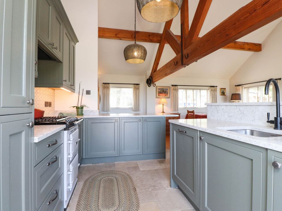 A kitchen with green cabinets and a marble countertop at Hafod in Nefyn