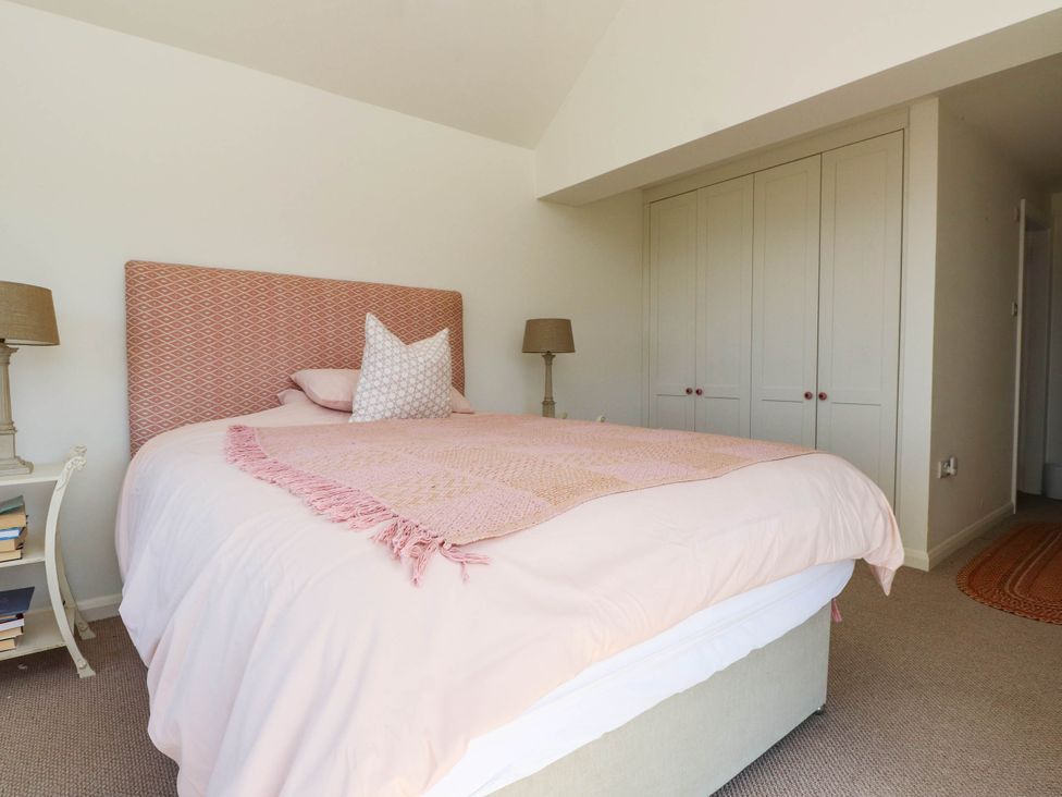 A bedroom with a bed and bedside tables at Hafod in Nefyn