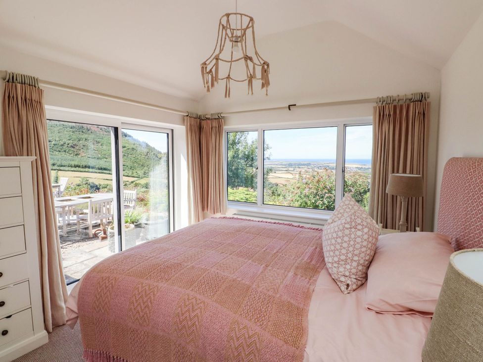 A bedroom with a bed and dresser at Hafod in Nefyn