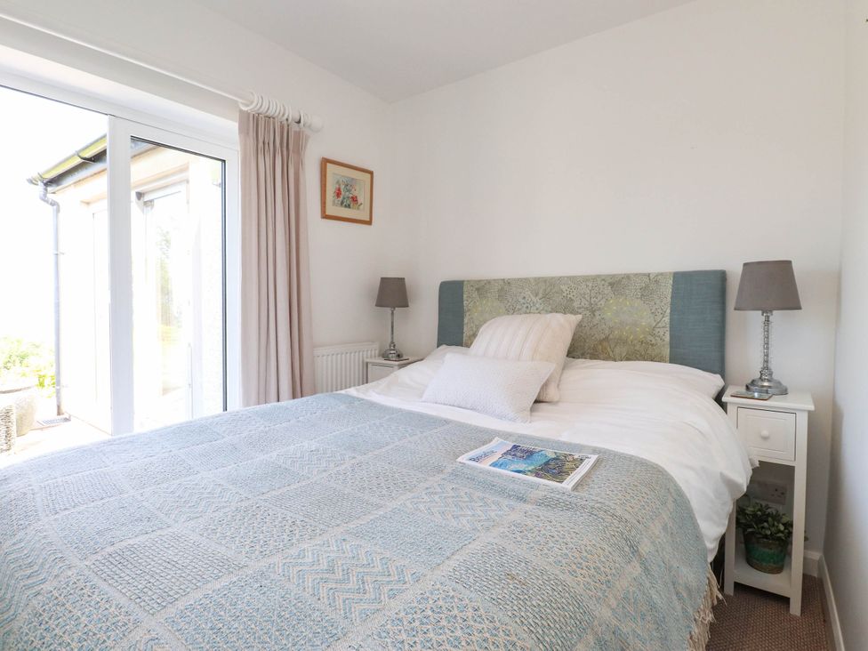 A bedroom with a bed and a bedside table at Hafod in Nefyn