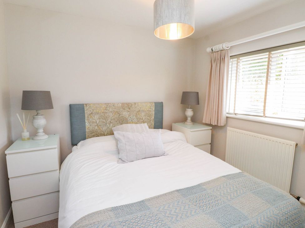 A bedroom with a bed and bedside tables at Hafod in Nefyn