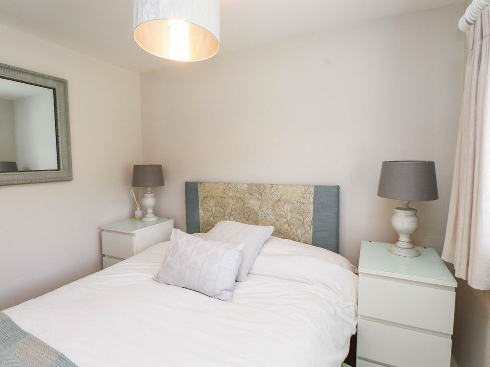 A bedroom with a bed and bedside tables at Hafod in Nefyn