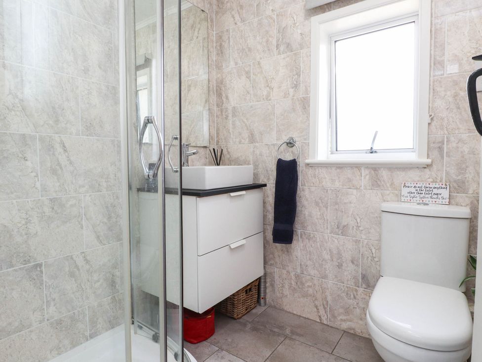 A bathroom with a shower, sink, and toilet at Hafod in Nefyn