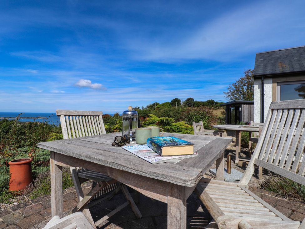 An outdoor seating area with a table and chairs at Hafod in Nefyn