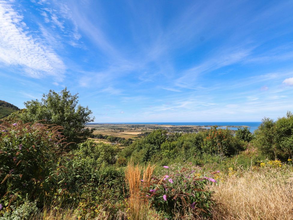 A view of trees and fields overlooking the sea at Hafod in Nefyn