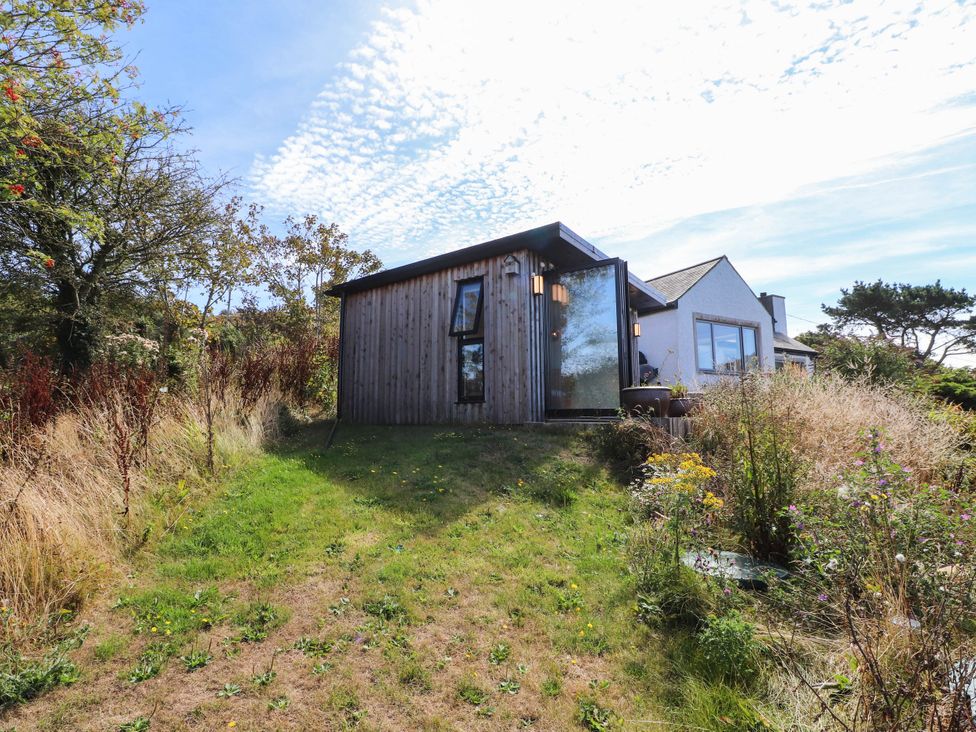 A house surrounded by grass and trees at Hafod in Nefyn