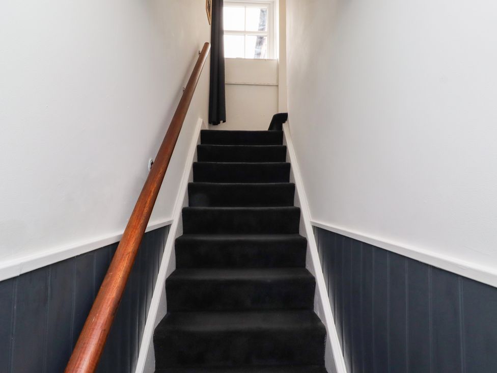 A staircase with a handrail at Cooper's Cottage in Morpeth