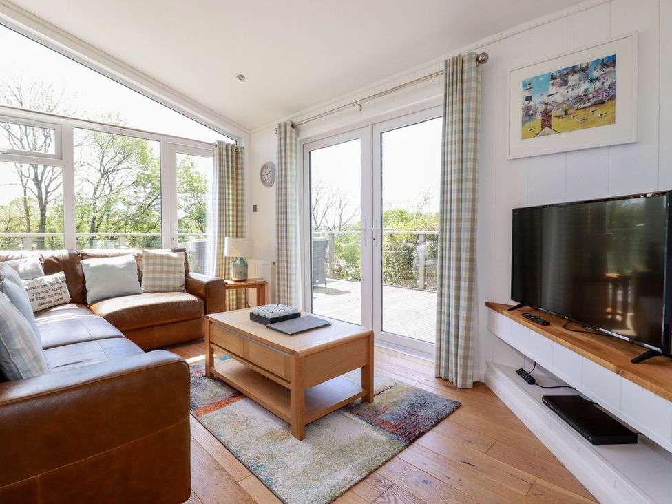 A living room with a sofa, coffee table and television at 4 Tree Tops Liskeard