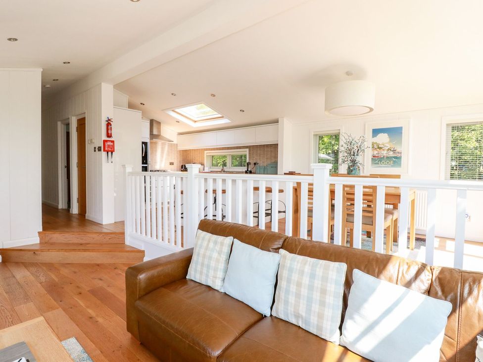 A living room with a sofa and dining area at 4 Tree Tops in Liskeard