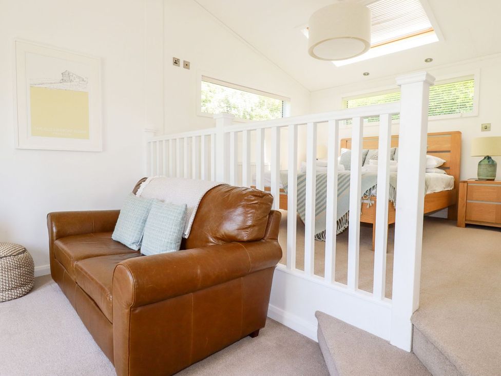 A bedroom with a sofa and bed at 4 Tree Tops in Liskeard