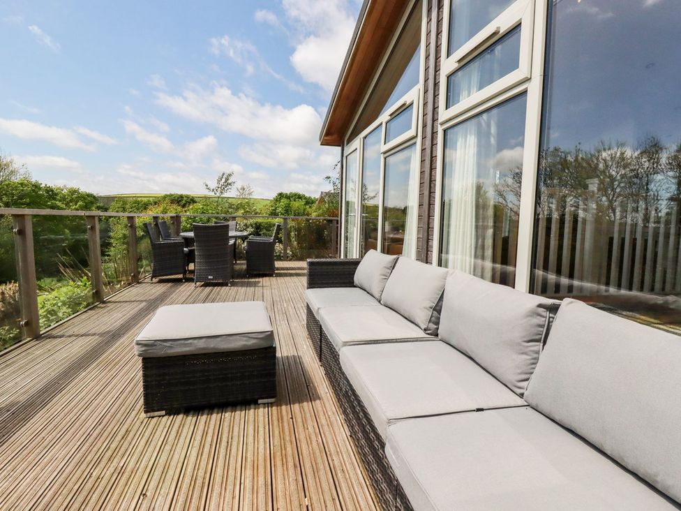 An outdoor patio with a sofa and dining set at 4 Tree Tops in Liskeard