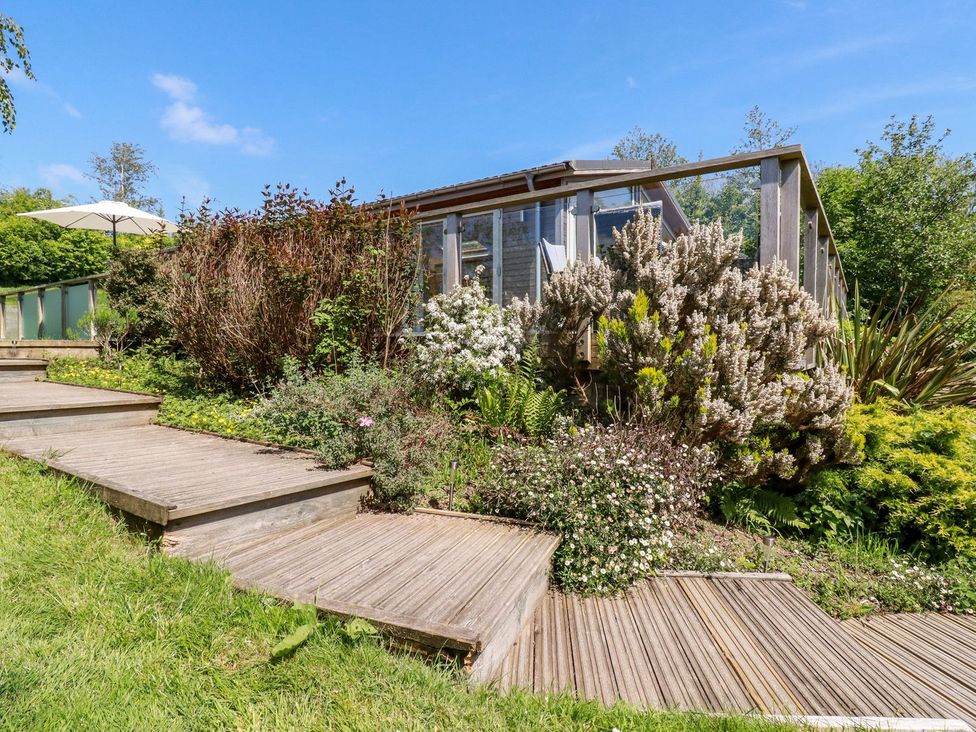 A garden with steps leading to an outdoor structure at 4 Tree Tops in Liskeard