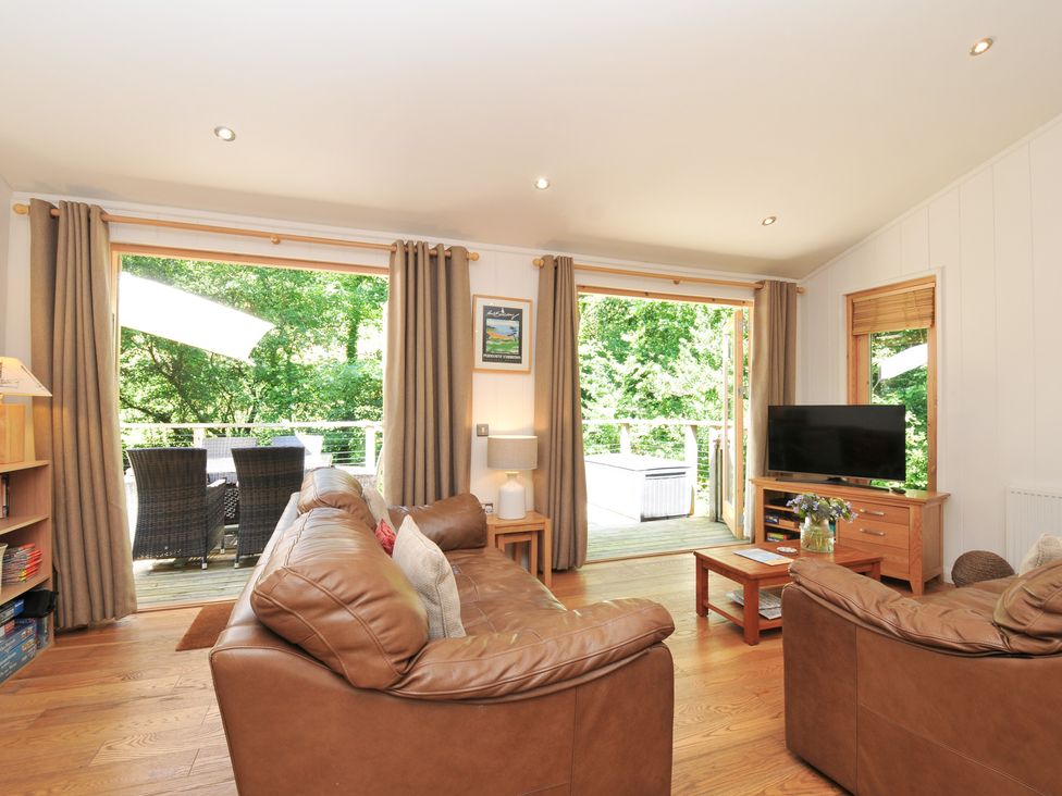 A living room with a sofa and television at 1 Stonerush Valley Liskeard