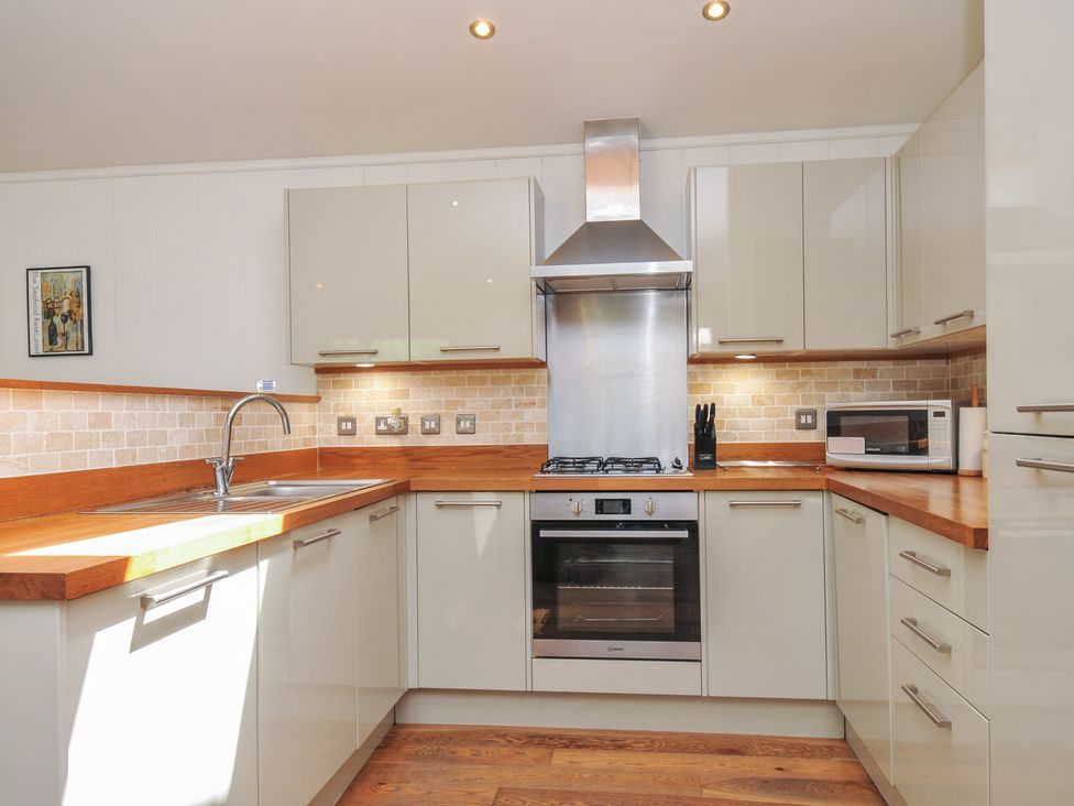 A kitchen with cabinets and appliances at 1 Stonerush Valley in Liskeard
