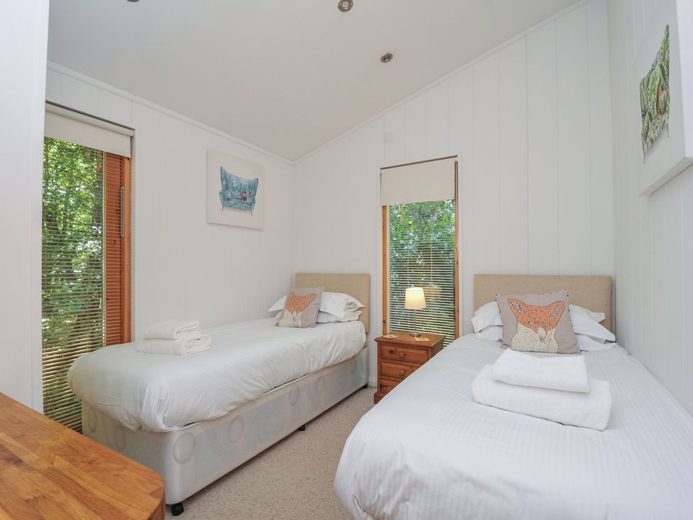A bedroom with two beds and a nightstand at 1 Stonerush Valley Liskeard