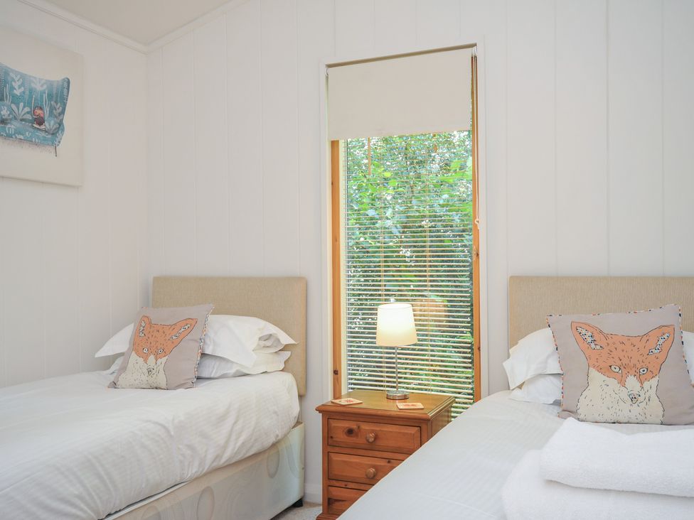 A bedroom with two beds and a window at 1 Stonerush Valley Liskeard