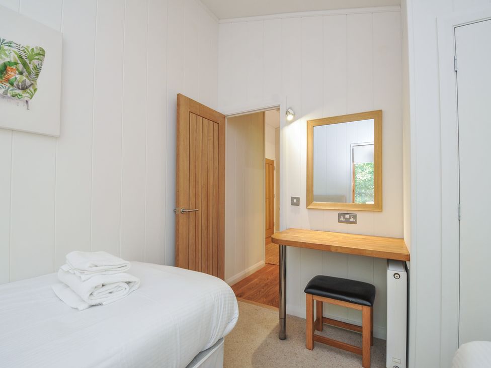 A bedroom with a bed and table at 1 Stonerush Valley, Liskeard