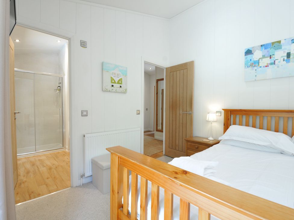 A bedroom with a bed and adjoining shower area at 1 Stonerush Valley in Liskeard
