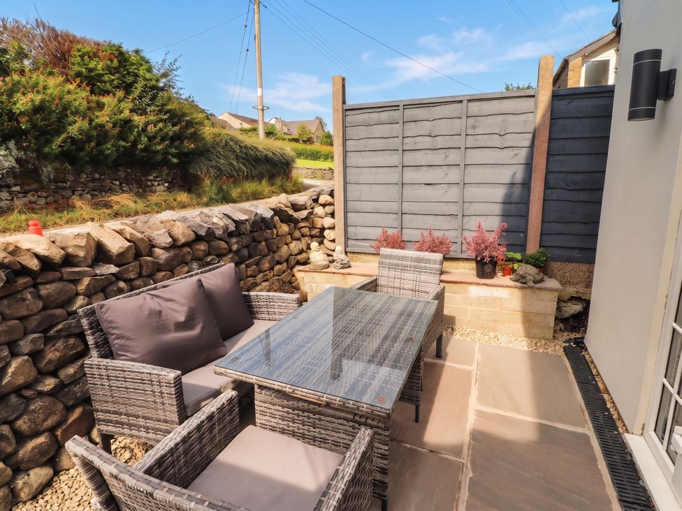 A garden seating area with a stone wall and plants at Fourways in 