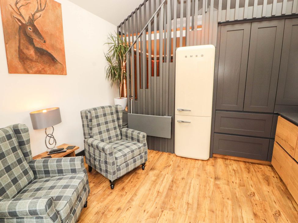 A living room with armchairs and a refrigerator at Fourways