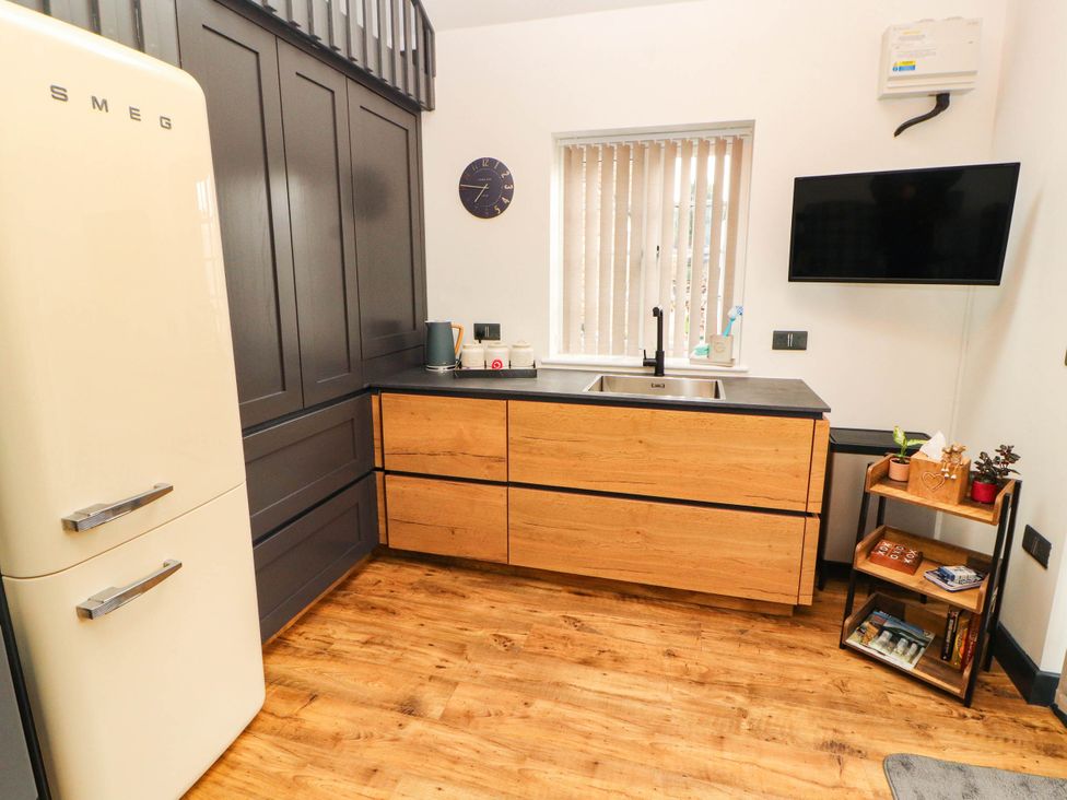 A kitchen with fridge, cabinets, sink and television at Fourways