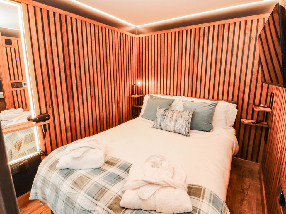 A bedroom with a bed and wooden walls at Fourways