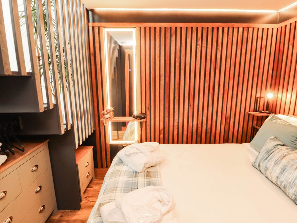 A bedroom with wooden wall and mirror at Fourways