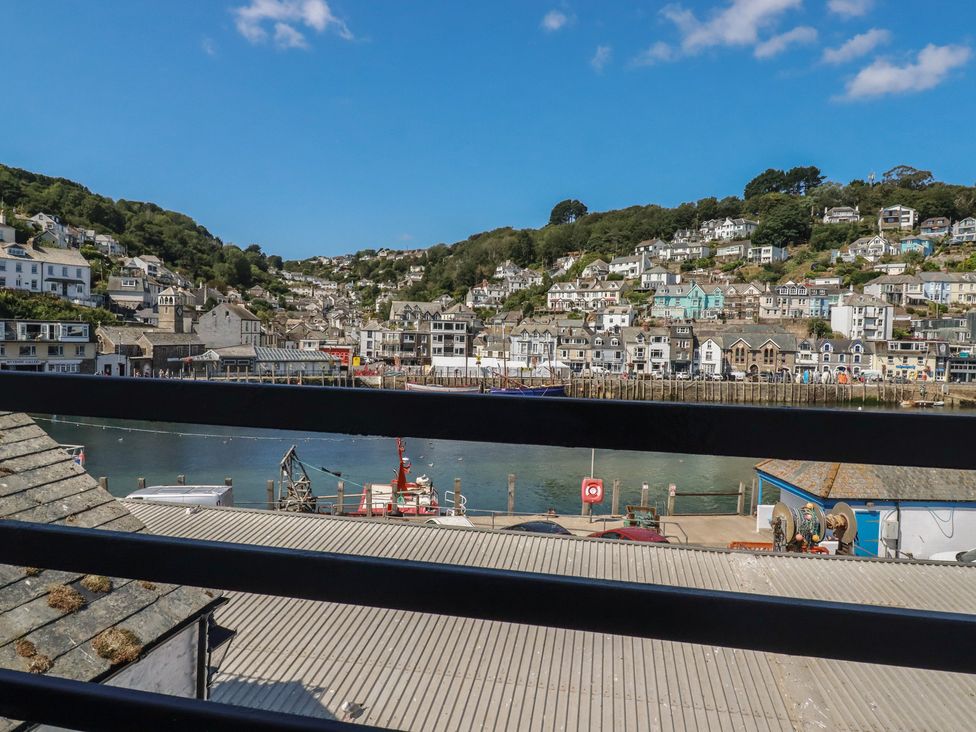 A view of buildings and boats along a river at Harbourside Retreat in Looe