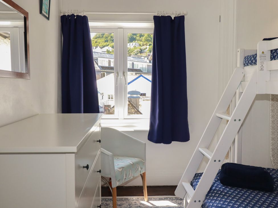 A bedroom with a bunk bed and a dresser at Harbourside Retreat in Looe