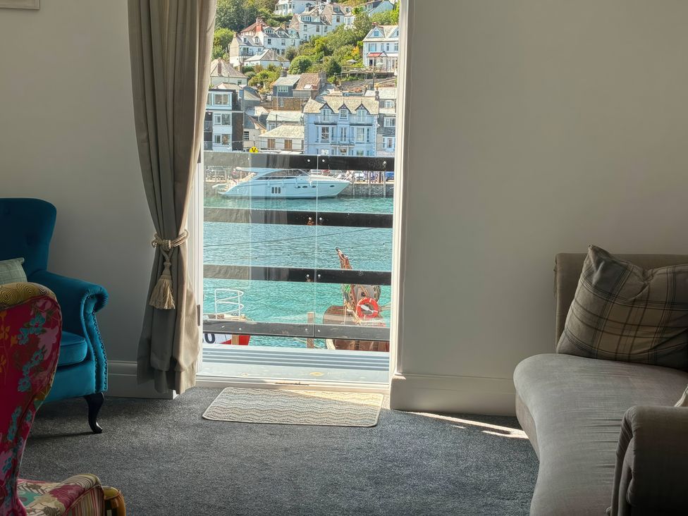 A living room with a window overlooking the water at Harbourside Retreat in Looe
