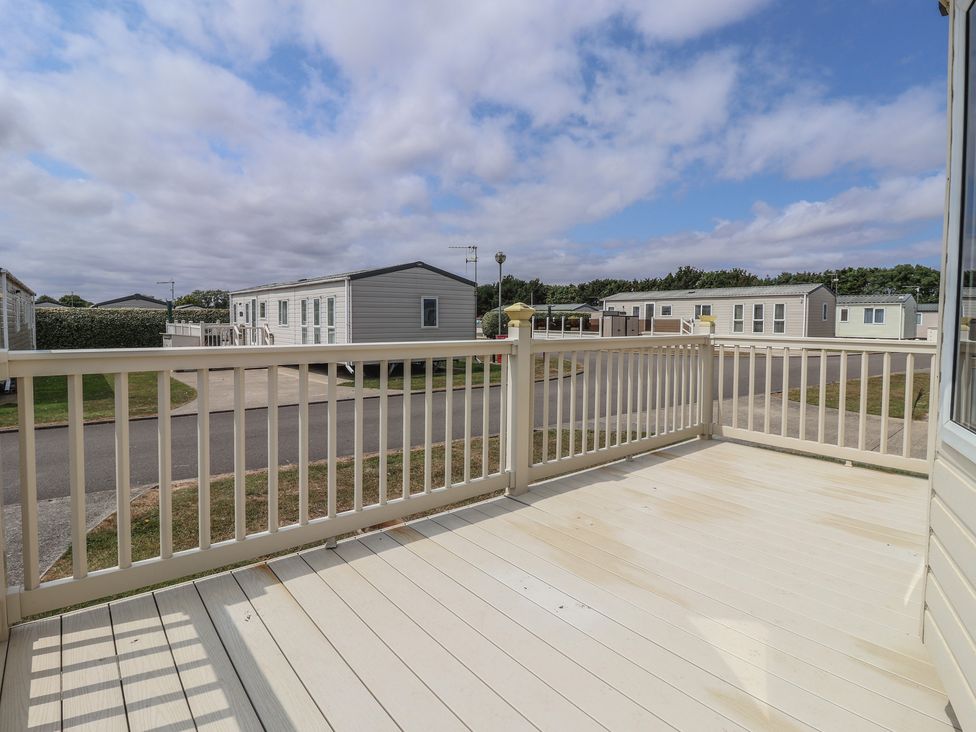 A deck area with a view of caravans at Paws and Relax in 