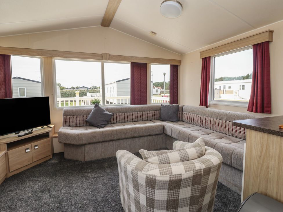 A living room with a sofa and television at Paws and Relax
